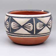 A small polychrome bowl decorated with a six-panel butterfly geometric design
 by Robert Tenorio of Santo Domingo