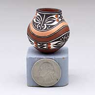 A miniature polychrome jar decorated with a rainbow and four-panel geometric design
 by Lilly M Salvador of Acoma