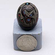 A miniature polychrome seed pot decorated with a sgraffito-and-painted kokopelli and geometric design plus a single inlaid bead
 by Ray Tafoya of Santa Clara