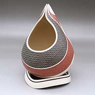 A polychrome tear-drop jar with an organic base and decorated with a cutout and geometric design
 by Elias Pena of Mata Ortiz and Casas Grandes