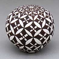 A black-on-white seed pot decorated with a pumpkin seed snowflake geometric design
 by Lisa Little of Acoma