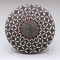 A polychrome seed pot decorated on the top with a North Star fine lien, pumpkin seed snowflake and geometric design
 by Rebecca Lucario of Acoma