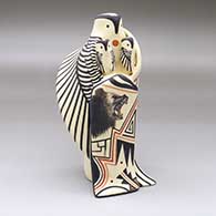 A standing owl storyteller figure with two chicks and a blanket with a bear and geometric design
 by Loren Wallowing Bull of Jemez