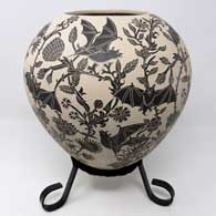 Sgraffito bat and branch design on a black and white jar with a custom stand