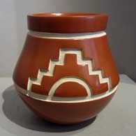 Carved red jar with sun and kiva step design