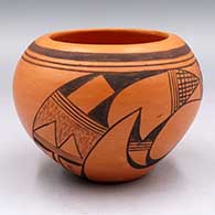 A black-on-red bowl with a 2-panel bird element and geometric design