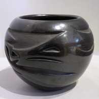 Black jar carved with an avanyu design
