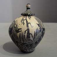 Sgraffito nature and wildlife design on a lidded black and white jar