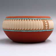 Polychrome bpowl with a lightly carved and painted feather and geometric design