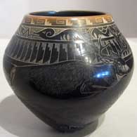 Sgraffito designs and a sienna rim on a black jar