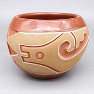A red and buff jar carved with an avanyu design