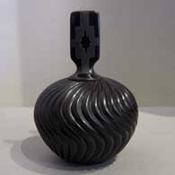 Melon design carved into a lidded black jar