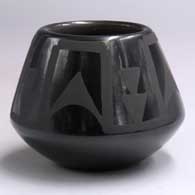 A black-on-black jar decorated with a geometric design around the body