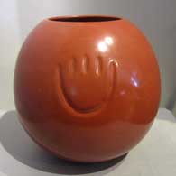 Bear paw imprint on a polished red pot by Tina Garcia
