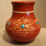 Three inlaid turquoise and sgraffito avanyu desighn on a polished red jar