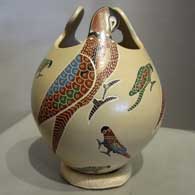 Sgraffito and painted multicolored parrt design on a sculptured jar
