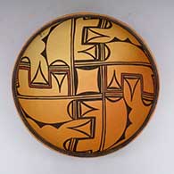 A black-and-red-on-yellow bowl decorated with a 4-panel geometric design inside