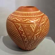 Sgraffito geometric design on a red jar