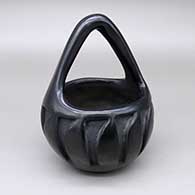 Black basket with a carved feather ring geometric design
 by Frances Salazar of Santa Clara