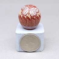 Titled Butterflies, a miniature white-on-red seed pot with a sgraffito butterfly and feather ring geometric design
 by Greg Lonewolf of Santa Clara
