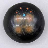 Black seed pot with sienna spots, a sgraffito butterfly and spider design, and inlaid stone details
 by Barbara Gonzales of San Ildefonso