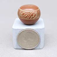 Miniature red seed pot with a sgraffito feather ring and geometric design
 by Geri Naranjo of Santa Clara