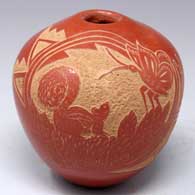 Red seed pot with a sgraffito squirrel, butterfly, pine branch and geometric design
 by Vangie Tafoya of Jemez