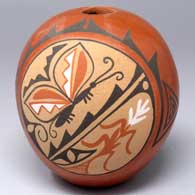Polychrome red seed pot with a painted butterfly and corn plant medallion with a geometric rainbow design
 by Phyllis M Tosa of Jemez