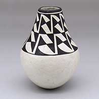 A black-on-white jar with a Mimbres geometric design above the shoulder
 by Lucy Lewis of Acoma