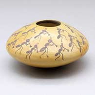 A small black-on-yellow seed pot with ant kokopelli figures above the shoulder
 by Shirley Benn of Hopi