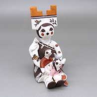 Polychrome storyteller wearing a tablita and holding two children, a kitten, ladybugs, a butterfly, a bird, and a painted cornstalk detail
 by Judy Lewis of Acoma