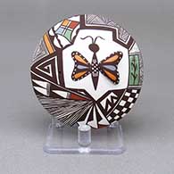 Polychrome seed pot with an applique and painted butterfly, fine line, cornstalk, checkerboard, and geometric design on top and an applique and painted ladybug detail on bottom
 by Carolyn Concho of Acoma