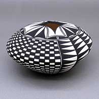 Black-on-white jar with a geometric cut opening, and a checkerboard and geometric design
 by Cletus Victorino of Acoma