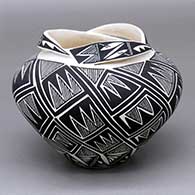 A black-on-white jar with a lock-and-key geometric design and a necklaced opening
 by Shauna Rustin of Acoma