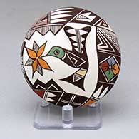 A polychrome seed pot decorated with a hummingbird, flower and geometric design
 by Carolyn Concho of Acoma