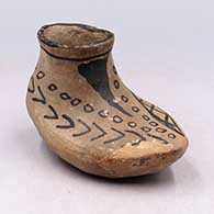 Brown moccasin with black painted design
 by Unknown of Cochiti