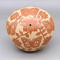 Red seed pot with a sgraffito butterfly, flower, plant, kiva step, and geometric design
 by Alvina Yepa of Jemez