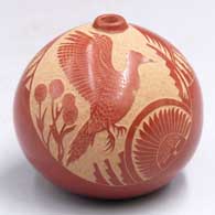 Small red seed pot with a raised rim and a sgraffito bird, sun face, milk thistle, feather and geometric design
 by Grace Medicine Flower of Santa Clara
