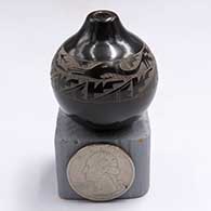 Miniature black seed pot with a raised rim and a sgraffito avanyu and geometric design above the shoulderF59
 by Geri Naranjo of Santa Clara