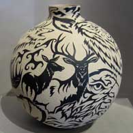 Sgraffito stylized animal design on a black and white jar