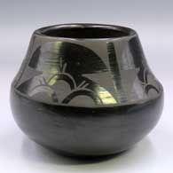 A black-on-black jar decorated above the shoulder with a 4-panel geometric design