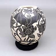 A black-on-white jar decorated with a sgraffito Day of the Dead design