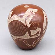 A red seed pot decorated with a sgraffito lizard and geometric design