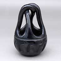 A black engagement basket with a geometric design carved around the body