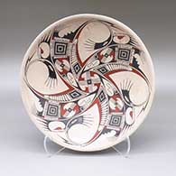 A polychrome marbleized clay shallow bowl decorated with a geometric design in the bottom