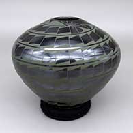 A green-on-black jar with a spiraling geometric design