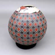 A polychrome jar decorated with a lizard and cuadrillos geometric design on top and bottom