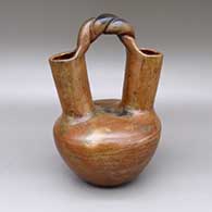 A red wedding vase with a pine-pitch coating, a braided handle, and fire clouds