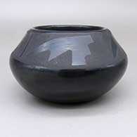 A black-on-black jar decorated with a four-panel kiva step and geometric design