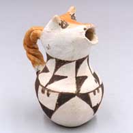 A polychrome cow's head pitcher with a twisted handle and geometric design